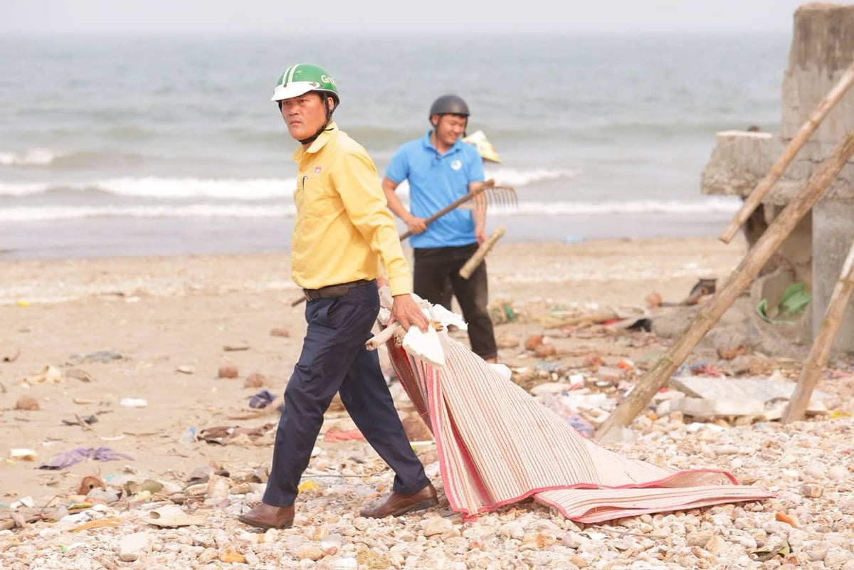 Lực lượng Ủy ban MTTQ xã Quỳnh Phú tham gia thu gom, vận chuyển rác thải, góp phần làm sạch môi trường bãi biển Quỳnh Nghĩa. Ảnh: Hữu Tình.