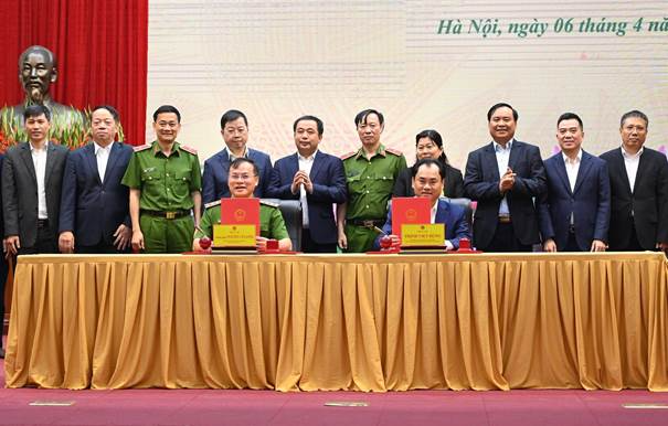 Thứ trưởng Thường trực Bộ Nông nghiệp và Môi trường Trịnh Việt Hùng và Thượng tướng, Thứ trưởng Bộ Công an Nguyễn Văn Long ký kết Biên bản ghi nhớ dưới sự chứng kiến của lãnh đạo hai Bộ. Ảnh: Kiều Chi.